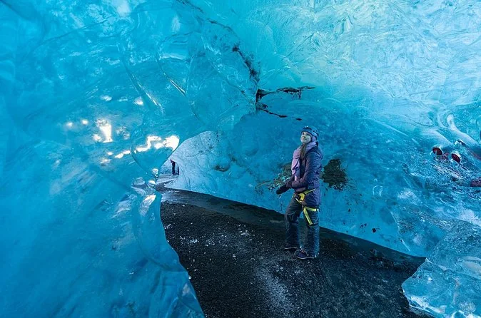 Eine leuchtend blaue Vatnajökull-Eishöhle mit einer Person darin